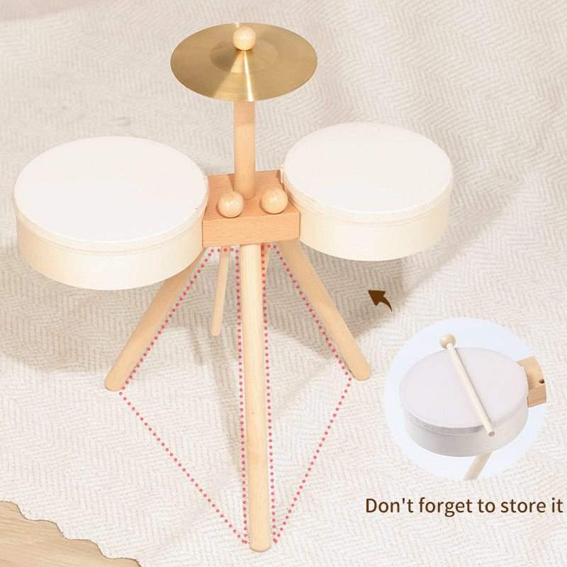 Houten Drumset van licht hout met twee crèmekleurige trommels, een goudkleurig bekken en houten drumstokken